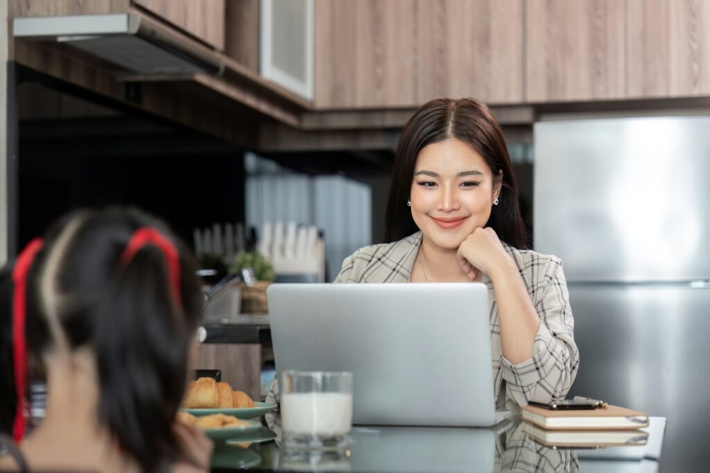 Seorang ibu rumah tangga menjalankan ide bisnis sampingan di depan laptop